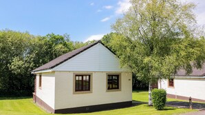 A small, single-story building with a pitched roof, a front door, and a small porch area. - 7 Brunston Avenue (Girvan)