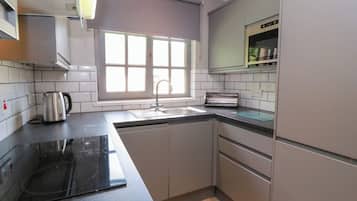 A kitchen with a built-in stove, a sink, and a window.