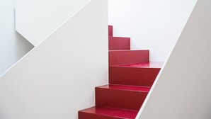 A staircase with a white wall and red steps. - GuestReady-Charming Aveiro Home (Aveiro)