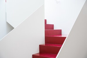 A staircase with a white wall and red steps. - GuestReady-Charming Aveiro Home (Aveiro)
