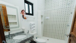 A bathroom with a marble sink, toilet, and shower area.