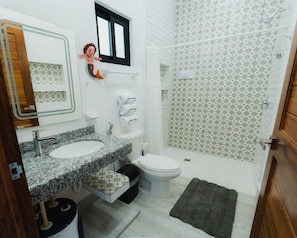 Een douche, handdoeken, zeep, toiletpapier
