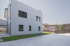 Ein modernes Gebäude mit flacher Fassade, zahlreichen Fenstern und einem gepflasterten Innenhof.