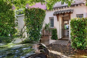 A rustic building with a tiled roof, a wooden door, and a small porch. - Holiday Home 'Maison Du Cap Jacuzzi, Tennis, Clim' with Private Terrace, Wi-Fi and Air Conditioning (Agde)