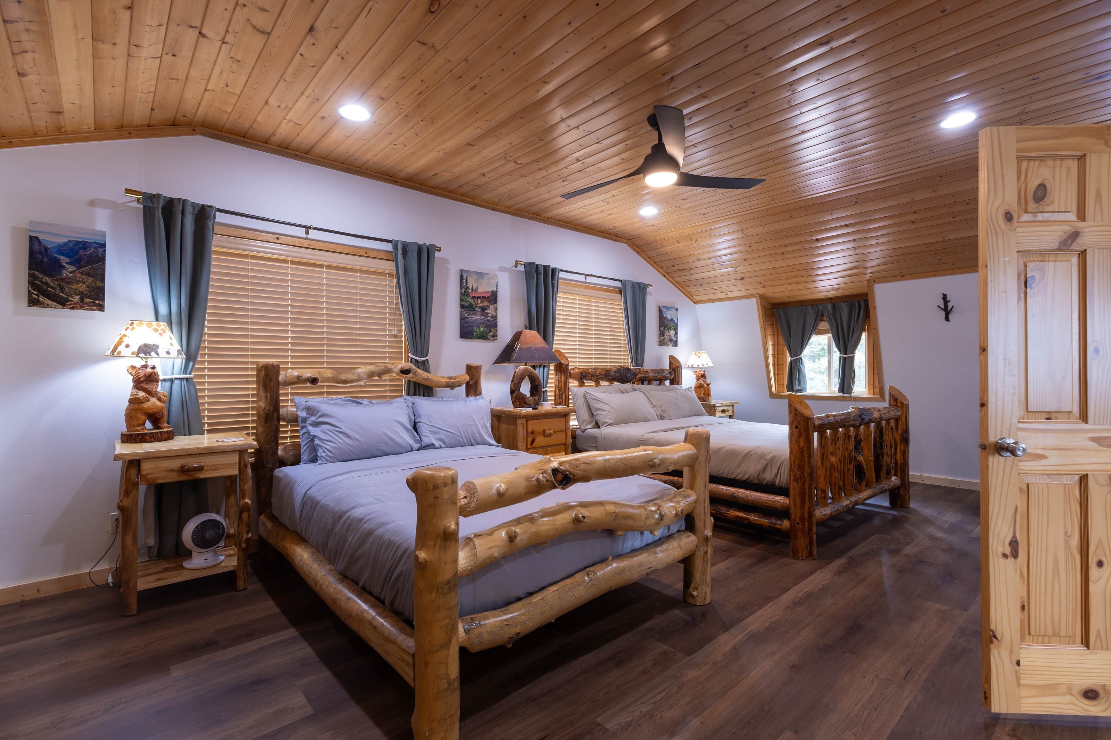 A bedroom with two wooden beds, a ceiling fan, and a wooden wardrobe.