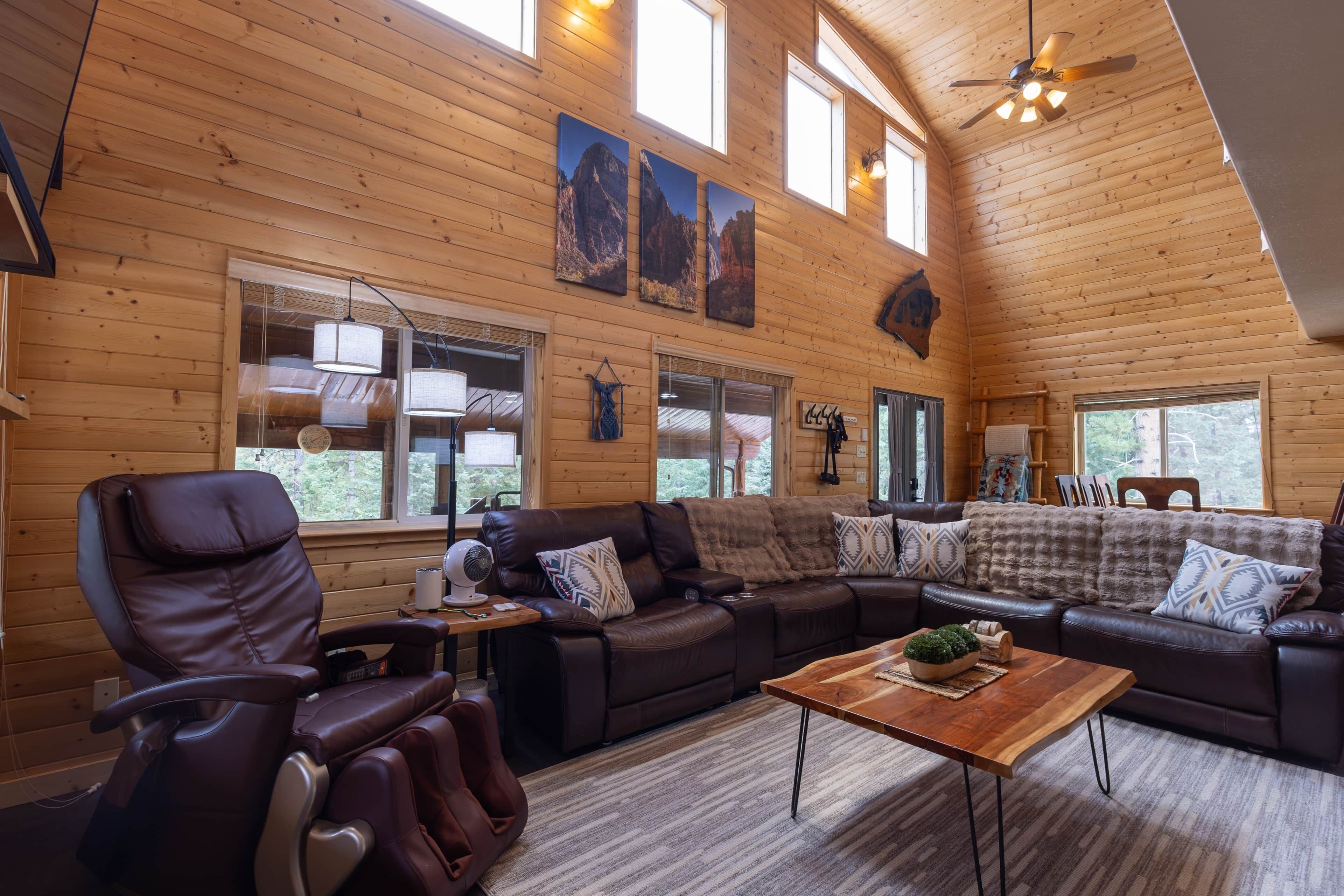 A spacious living room with a leather sofa, a recliner, and a wooden coffee table.
