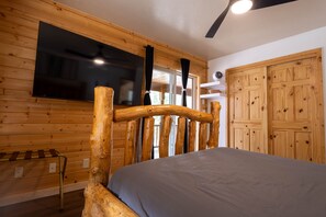 A wooden interior with a bed, a television mounted on the wall, and a wardrobe. - Rev & Rest Lodge Duck Creek (Duck Creek Village)
