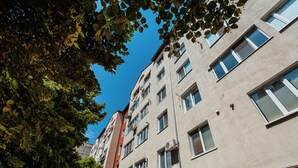 Monikerroksinen rakennus, jossa on tasainen julkisivu, useita ikkunoita ja parvekkeita.