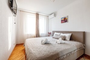 A hotel room with a bed, curtains, a painting, and a window. - 2BR • Fireplace & Panoramic Views • Near Dendrarium (Chișinău)
