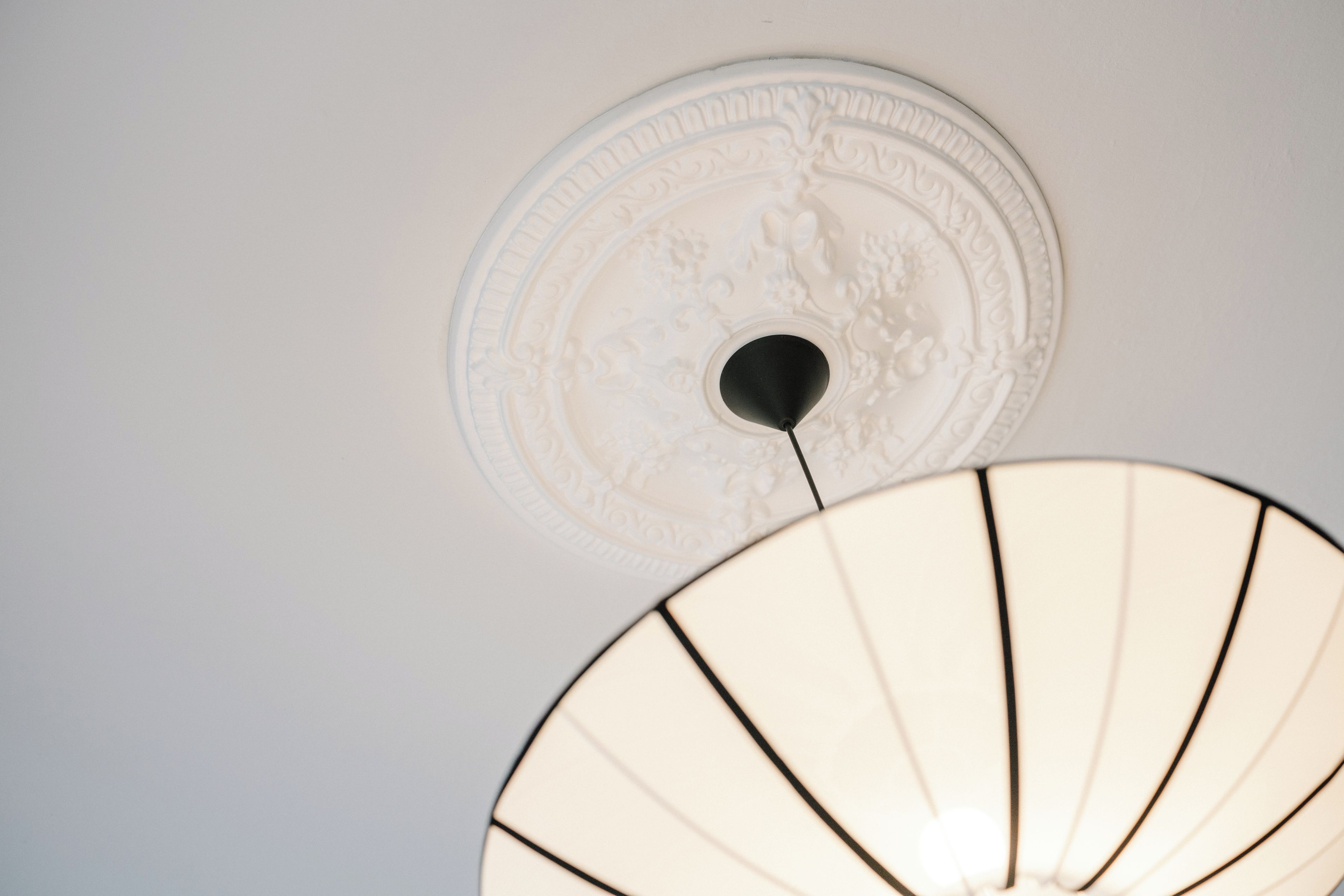 Techo con un diseño circular decorativo y una lámpara colgante.