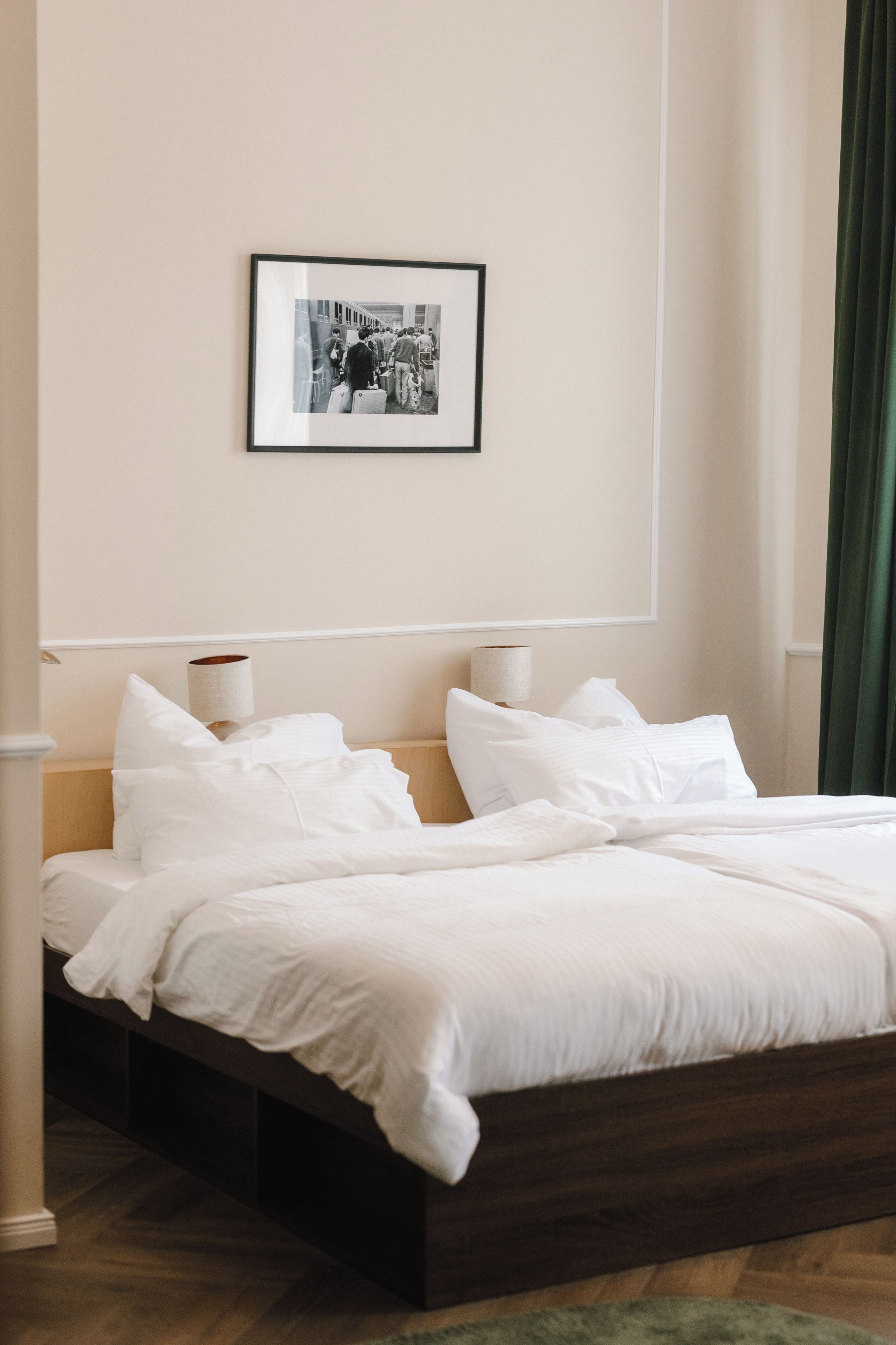 A neatly made bed with white linens in a hotel room.