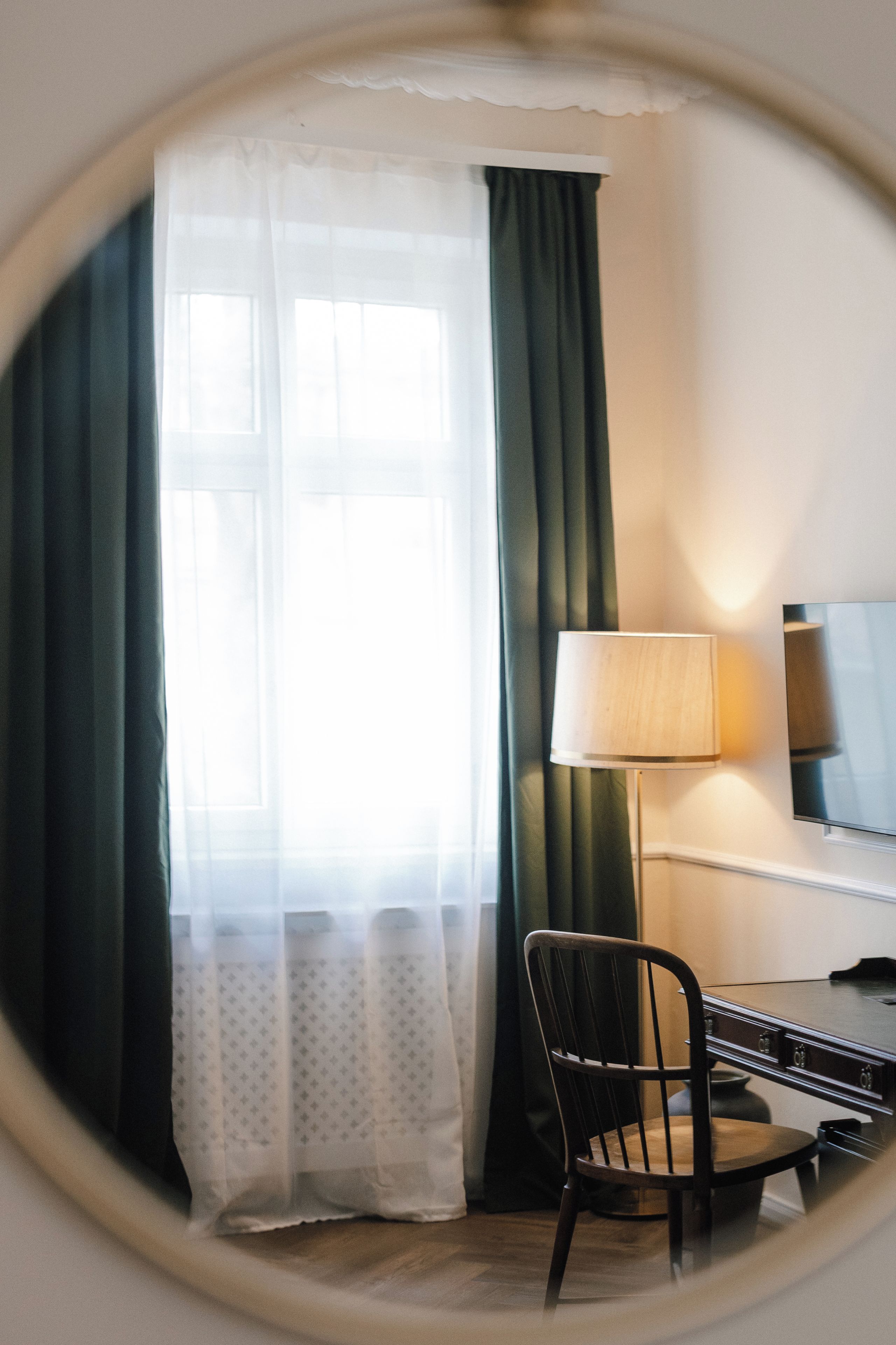 Ein Zimmer mit Bett, Schreibtisch, Stuhl und Lampe.
