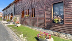 Ein Holzhaus mit vielen Fenstern und Blumenkästen.