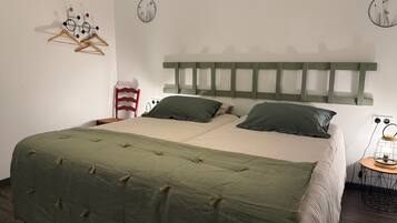 Une chambre à coucher comprenant un lit, une chaise, une table de chevet avec une lampe et des œuvres d’art murales.