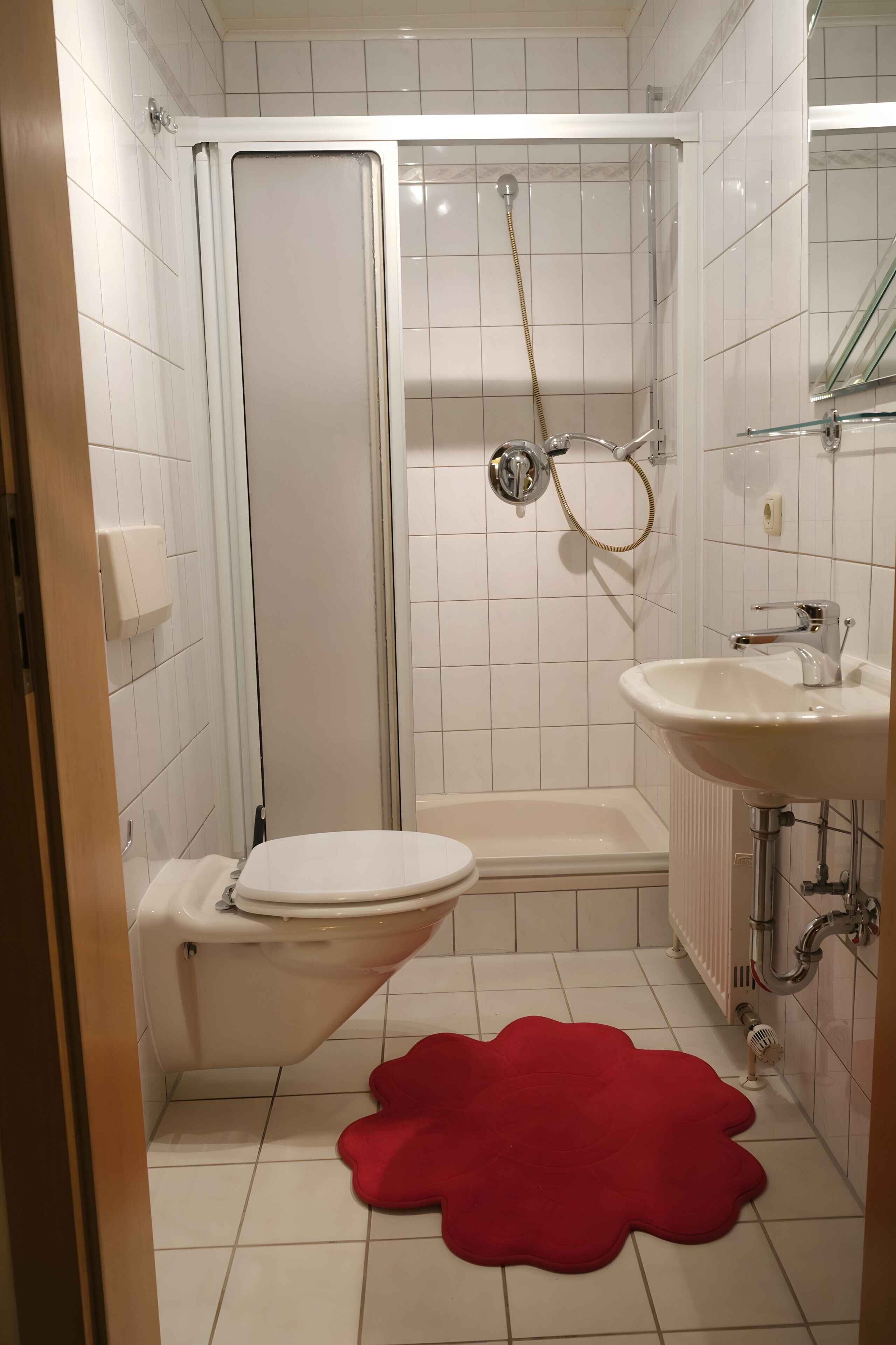 A bathroom with a toilet, shower, and sink.