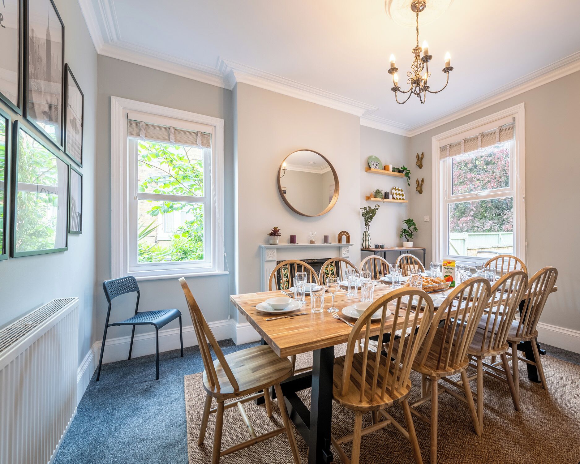 A dining room with a wooden table set for six, surrounded by six wooden chairs.