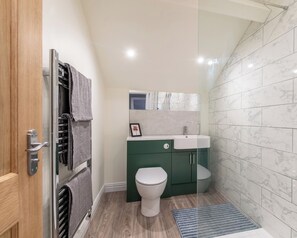 Un baño moderno con inodoro, lavabo y zona de ducha.
