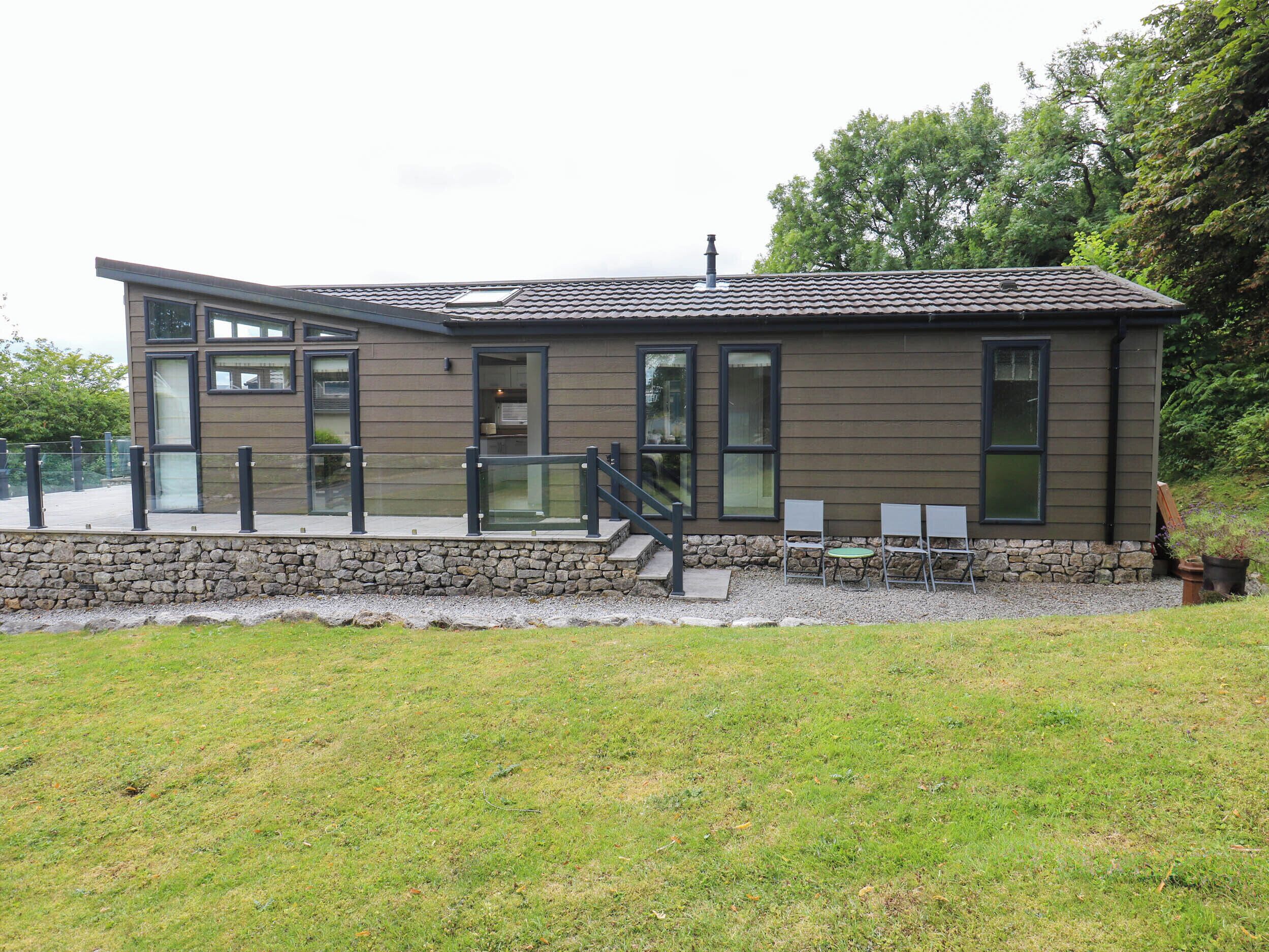 A modern building with a stone foundation, large windows, and a flat roof.
