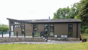 A modern building with a stone foundation, large windows, and a flat roof. - Dales Retreat (Skipton)