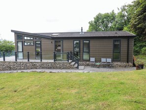 A modern building with a stone foundation, large windows, and a flat roof. - Dales Retreat (Skipton)