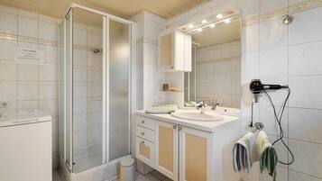 A bathroom with a shower, a sink, a mirror, and a hairdryer.