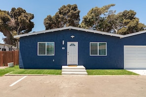 A single-story building with a front door, two windows, and a garage door. - 3BR Chula Vista Getaway Near Gaylord Pacific (Chula Vista)