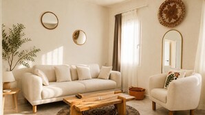 A living room with a sofa, armchair, coffee table, and a mirror on the wall. - Ciello Hotel (Bodrum)