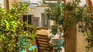 A rustic wooden-framed mirror reflecting a dining area with a table and chairs, surrounded by greenery. - Ciello Hotel (Bodrum)