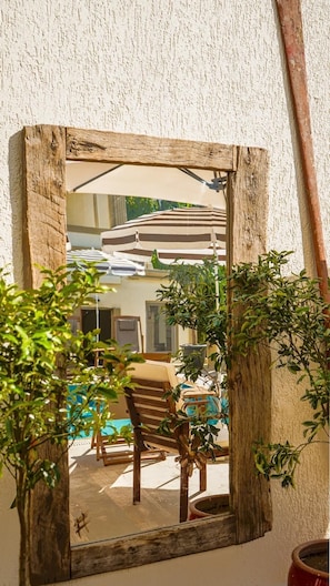 A rustic wooden-framed mirror reflecting a dining area with a table and chairs, surrounded by greenery. - Ciello Hotel (Bodrum)