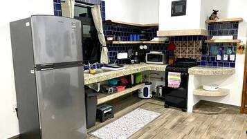 A compact kitchen with a refrigerator, microwave, and a sink.