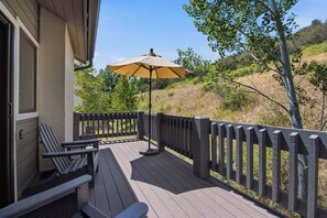 A wooden deck with a bench and an umbrella, overlooking a hillside. - Ridgepoint Townhome 166 - 4 Bedroom Residence (Beaver Creek)
