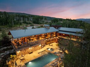 A modern resort with a large pool, outdoor seating, and a view of the surrounding forest. - Ultra Luxury Retreat - Private Hot Tub, Firepits (Silverthorne)