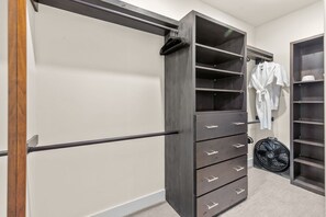 A walk-in closet with a gray wardrobe, multiple drawers, and a hanging rack. - NEW! Ultra Luxury Mtn Estate - Hot Tub, Firepits (Silverthorne)