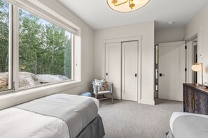 A bedroom with a large window, a bed, a chair, and a dresser. - NEW! Ultra Luxury Mtn Estate - Hot Tub, Firepits (Silverthorne)