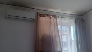 A room with a window, a curtain, and an air conditioning unit. - B&B TETYANa (Naples)