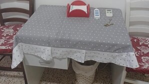 A small dining table with a polka dot tablecloth, a red object on the table, and a white chair with a red floral cushion. - B&B TETYANa (Naples)