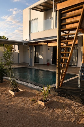 A modern two-story house with a swimming pool, a wooden staircase, and potted plants. - Comfortable and spacious villa (250m2)  few minutes drive from stunning beaches (Grand Baie)