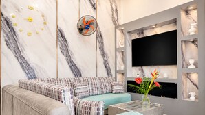 Una sala de estar moderna con un sofá, una mesa de centro y un televisor montado en la pared.