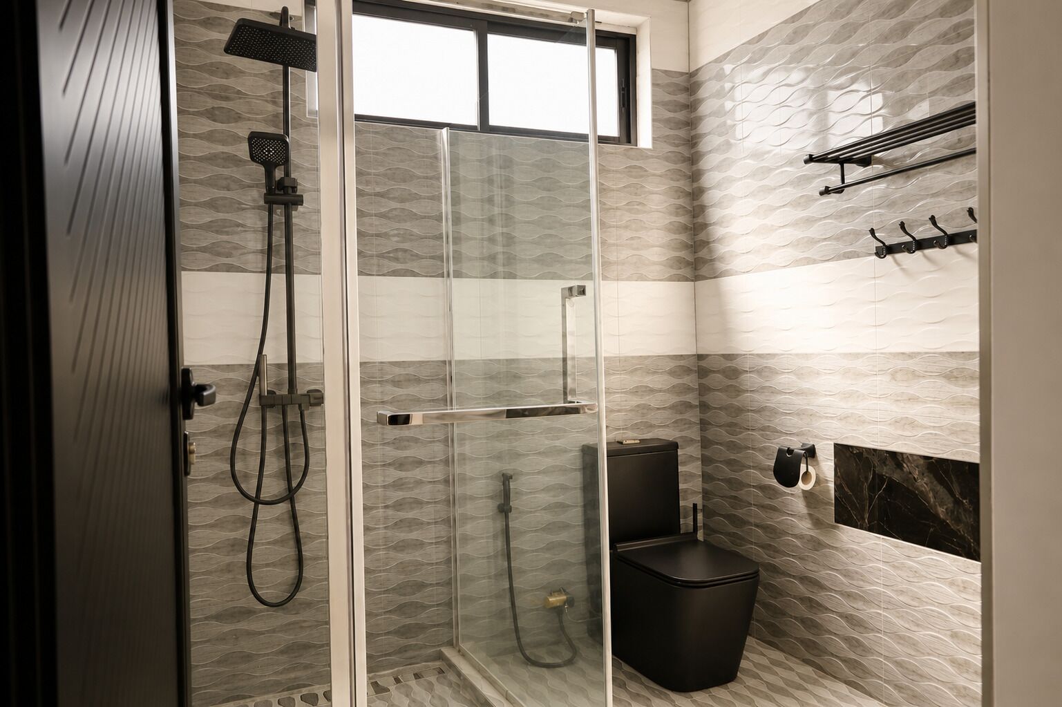 A modern bathroom with a glass-enclosed shower, a black toilet, and a towel rack.