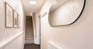 A hallway with a staircase, a wall-mounted mirror, and framed pictures. - 125 Columbus Ravine (Scarborough)