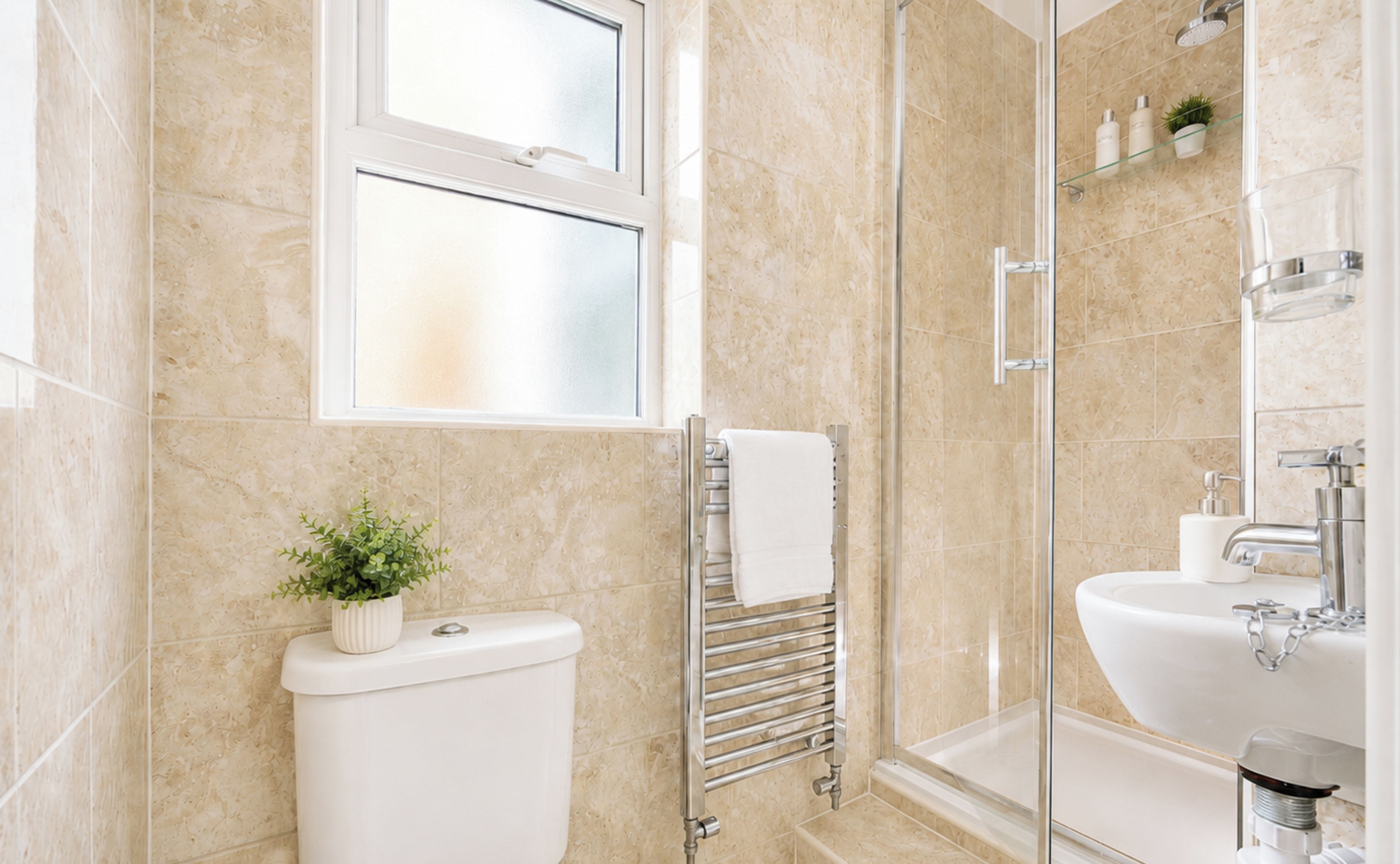 A modern bathroom with a glass shower enclosure, a toilet, and a sink.