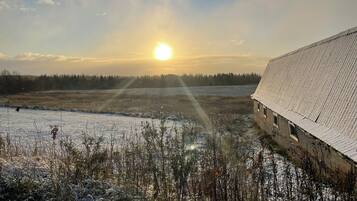 Ein schneebedecktes Feld mit einem Gebäude mit geneigtem Dach.