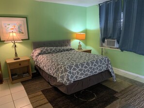 A bedroom with a bed, nightstands, a lamp, a window with curtains, and a wall painting. - BEACH Studio #2 The Village of Lauderdale-by-the-Sea (Lauderdale-by-the-Sea)