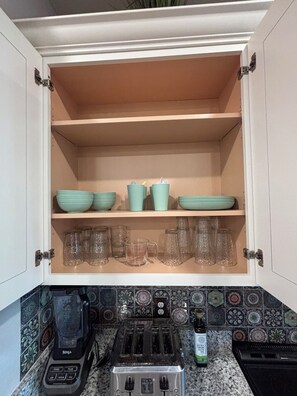 Una cocina con un tostador, una cafetera y una botella de aceite de oliva virgen extra sobre la encimera.