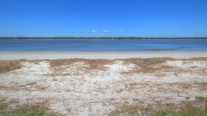 Ein Strand mit blauem Himmel und ruhiger See.