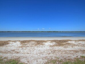 Ein Strand mit blauem Himmel und ruhiger See.
