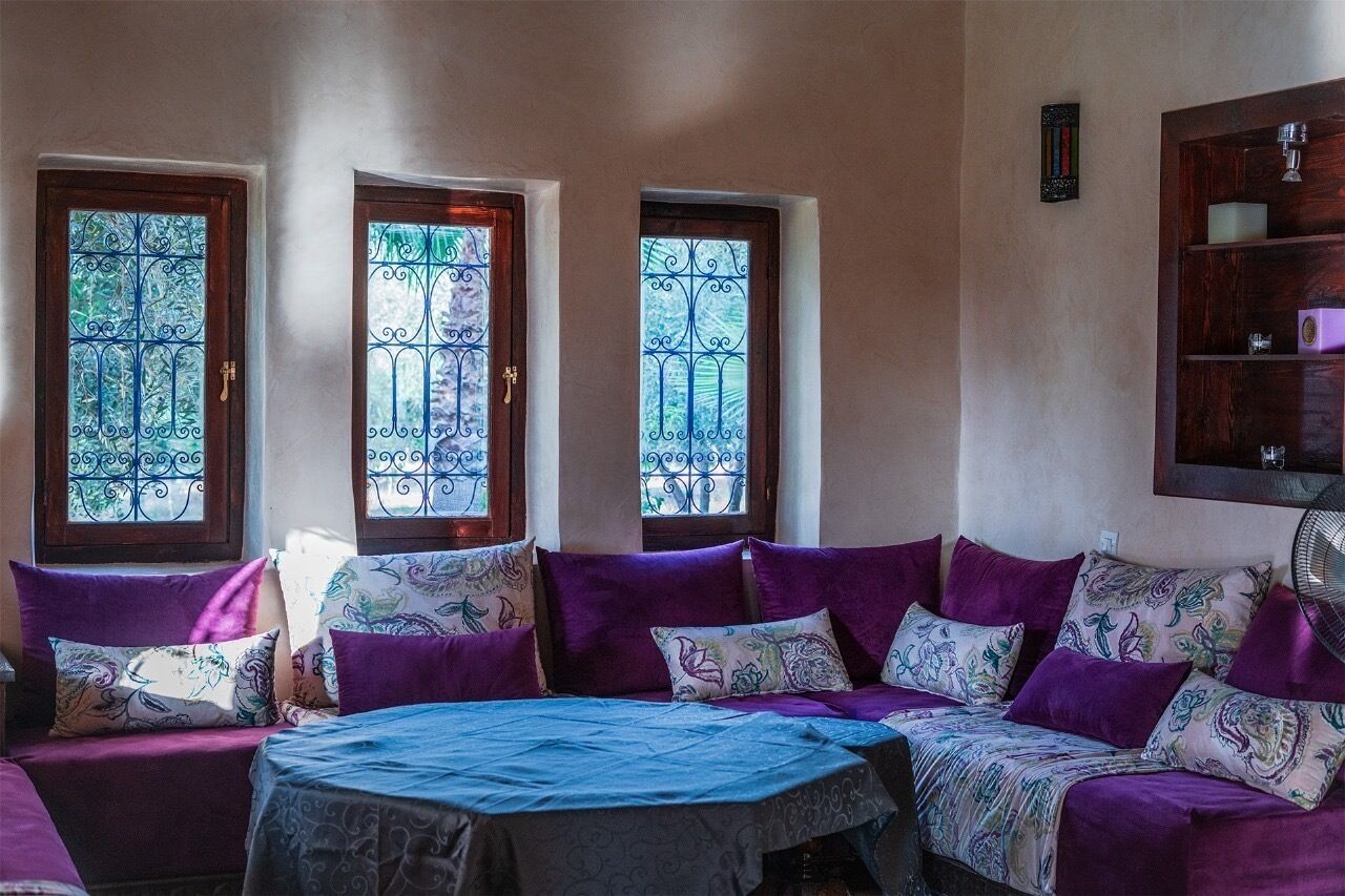 Ein Zimmer mit einer Sofagarnitur, einem Bett und einem an der Wand befestigten Regal.