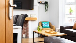 A modern living room with a sofa, a coffee table, and a TV mounted on the wall. - 38 Ashville Avenue (Scarborough)