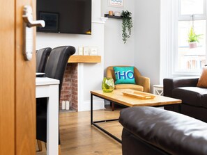 A modern living room with a sofa, a coffee table, and a TV mounted on the wall. - 38 Ashville Avenue (Scarborough)