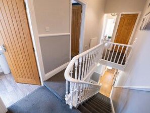 A staircase with a white handrail leading to a landing, a wooden door, and a carpeted floor. - 38 Ashville Avenue (Scarborough)